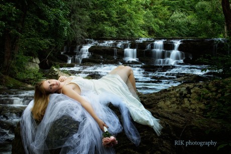bride lying on a rock by a waterfall