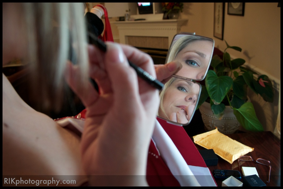 Bride applying makeup before her wedding