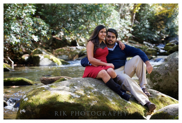 Engaged couple sitting on a boulder